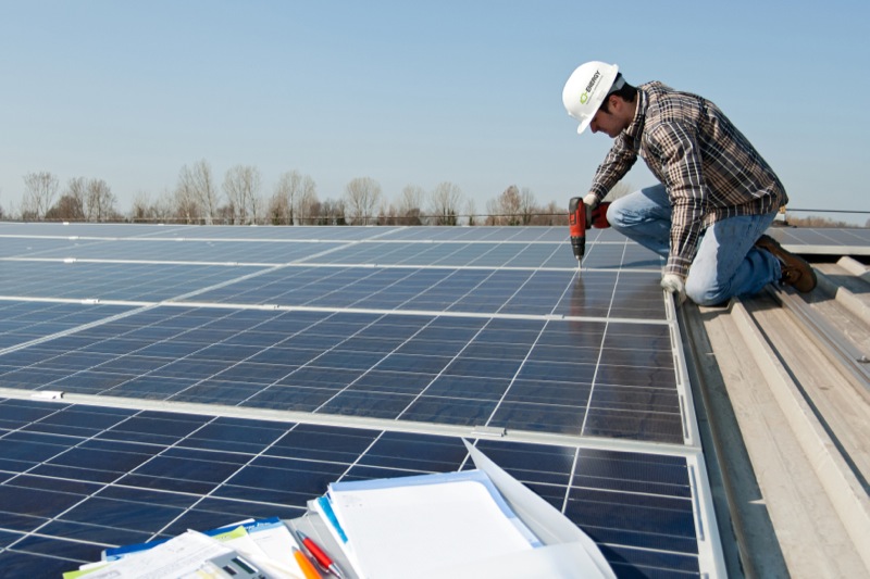 Man with scredriver on a photovoltaic plant