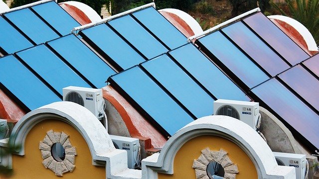 Haus mit Photovoltaik-Anlage auf dem Dach und Klimagerät